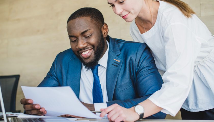 deux personnes au travail discutant et souriants